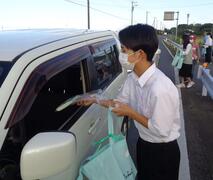 高校生がドライバーに啓発グッズを渡している様子