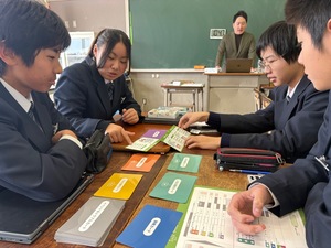 カードゲームで人生の疑似体験をする生徒たち