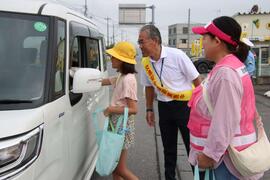 小学生がドライバーにグッズを渡している様子