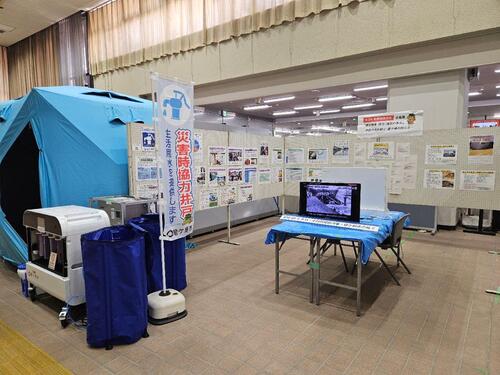 展示の様子。令和8年度熊本地震被災地に提供中のシャワーテントの実物展示も。