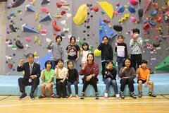 参加した子どもたちと野口さんでクライミングウォールの前で記念撮影