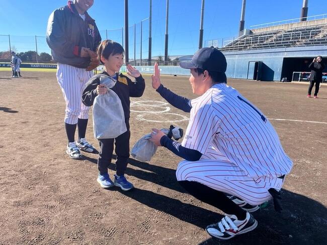 表彰式で大学生とハイタッチしている様子