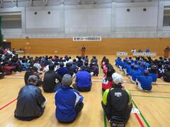 スポーツ少年団本部交流大会開会式にて、教育長挨拶を聞く全体の写真。